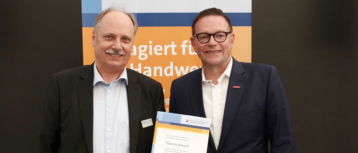 Thomas Bausch mit seiner Ehrenurkunde f&uuml;r langj&auml;hriges Engagement im Meisterpr&uuml;fungswesen und Kammerpr&auml;sident Klaus Hofmann.