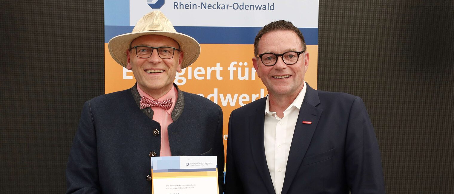 Olaf Mayer mit seiner Ehrenurkunde f&uuml;r langj&auml;hriges Engagement im Meisterpr&uuml;fungswesen und Kammerpr&auml;sident Klaus Hofmann.