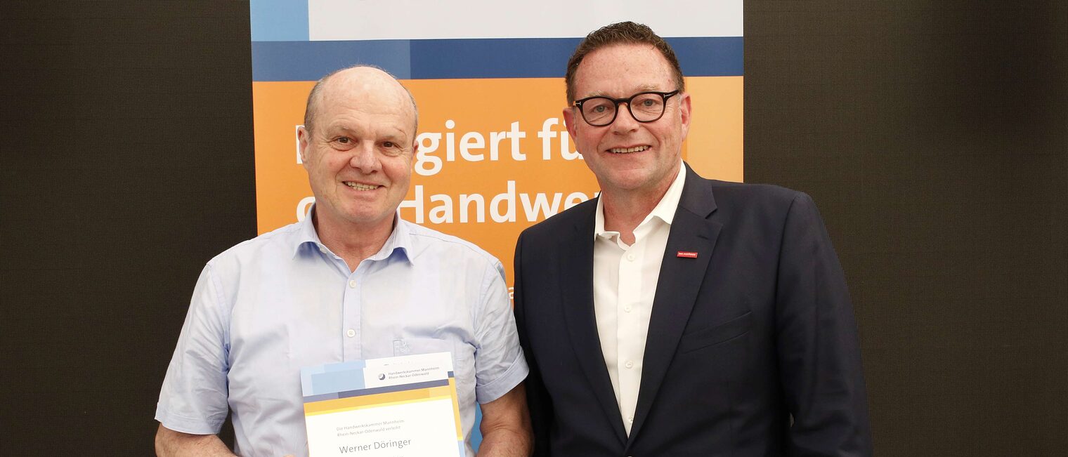  Werner D&ouml;ringer mit seiner Ehrenurkunde f&uuml;r langj&auml;hriges Engagement im Meisterpr&uuml;fungswesen und Kammerpr&auml;sident Klaus Hofmann.