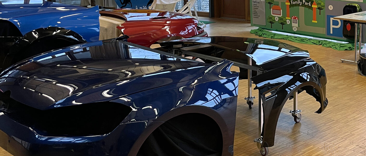 Autoteile mit der Farbe dunkelblau zerlegt in einem Raum zur Demonstration aufgebaut.