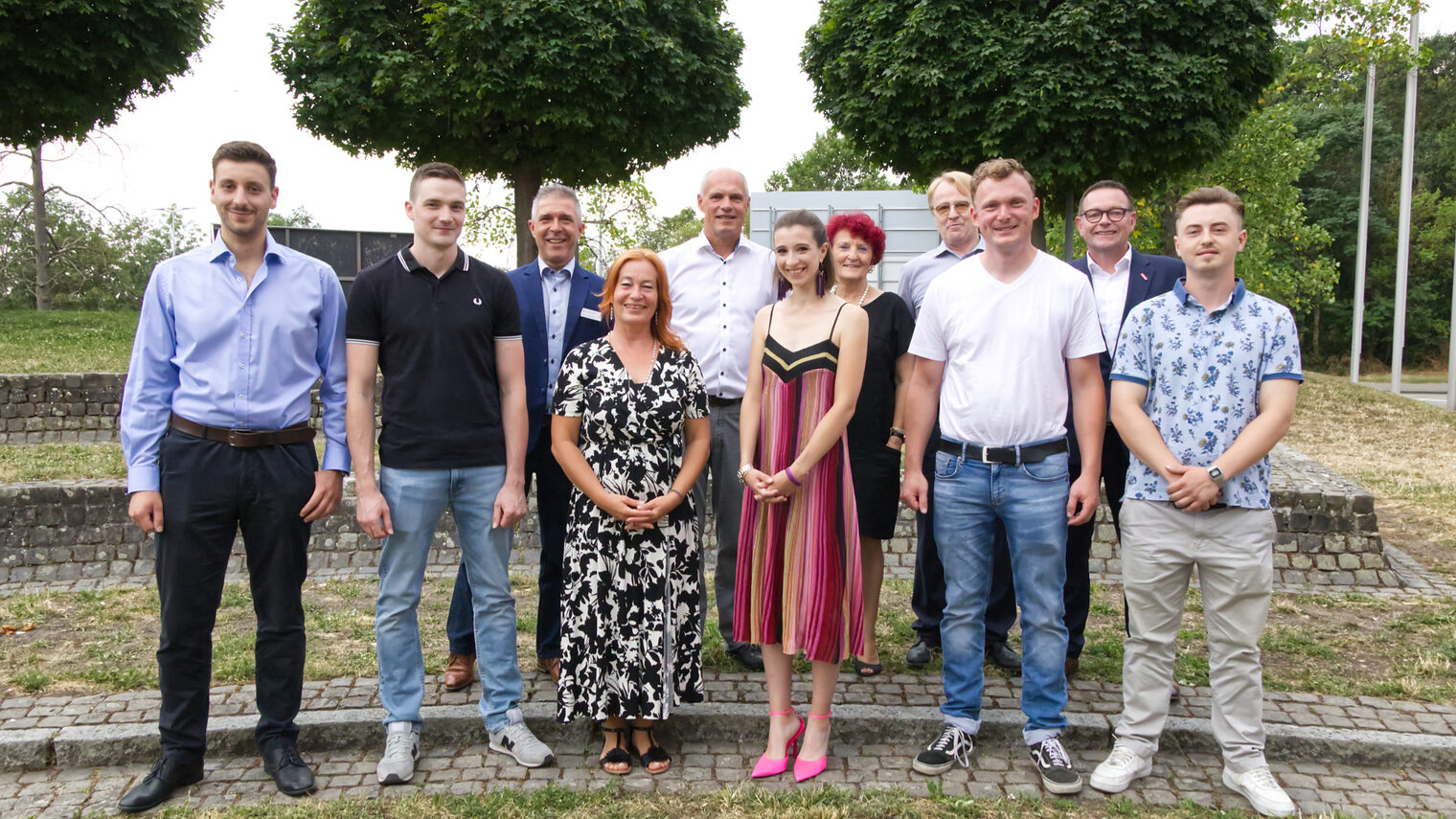 8 Männer und 3 Frauen aufgestellt in zwei Reihen stellen sich dem Fotografen.