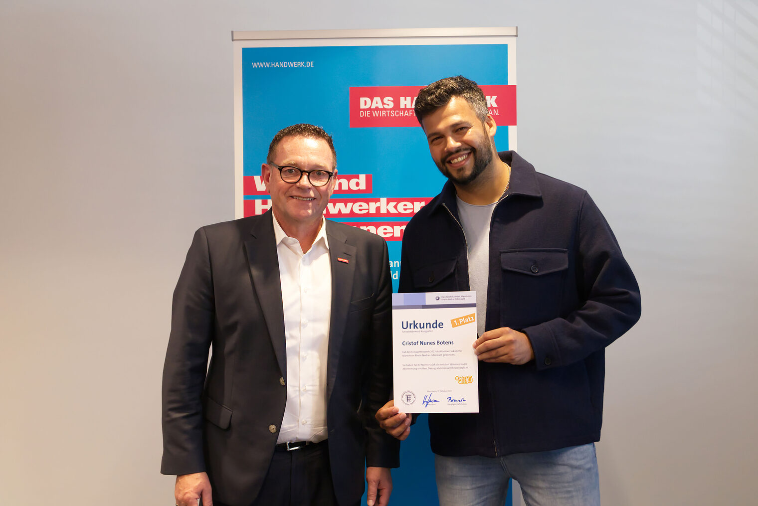Maler- und Lackierermeister Cristof Nunes Botens neben dem Präsidenten der Handwerkskammer, Klaus Hofmann, der ihm zum Gewinn gratuliert