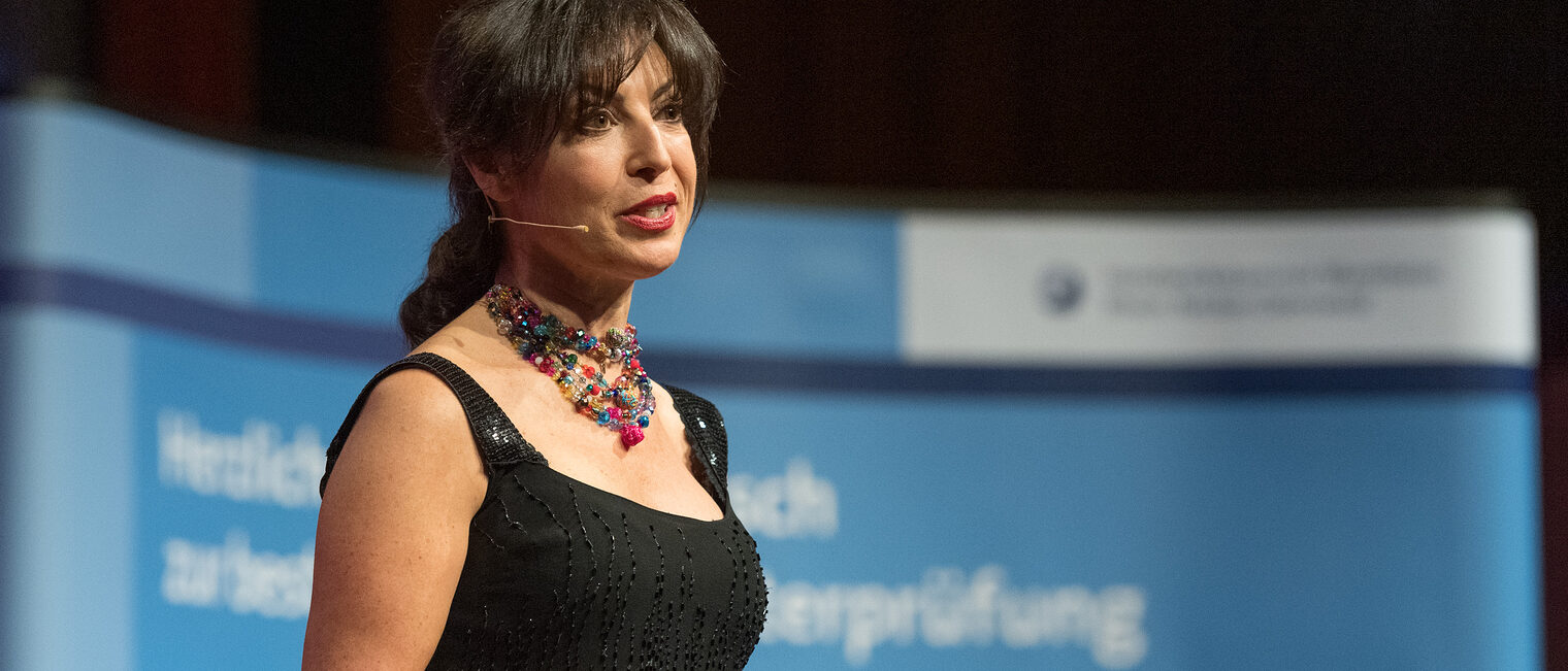 Moderatorin Frau Rosa Omeñaca Prado auf der Bühne der Meisterfeier 2023