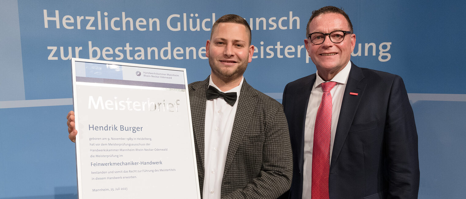 Handwerkskammerpräsdent Klaus Hofmann mit Feinwerkmechanikermeister Hendrik Burger.