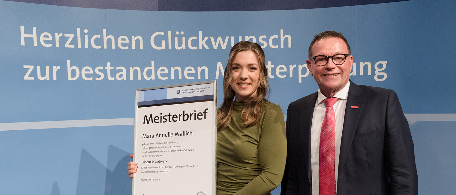 Handwerkskammerpräsdent Klaus Hofmann mit Friseurmeisterin Mara Annelie Wallich.