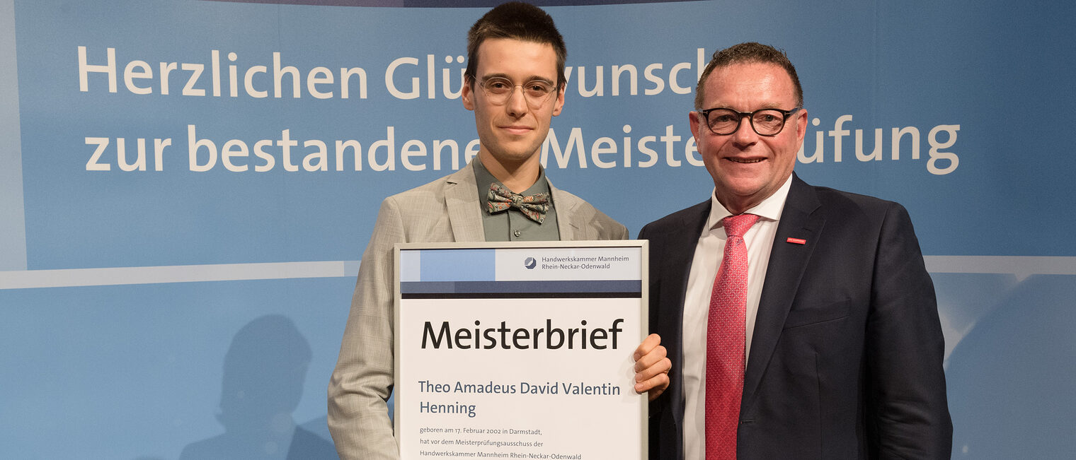 Handwerkskammerpräsdent Klaus Hofmann mit Hörakustikermeister Theo Amadeus David Valentin Henning. 