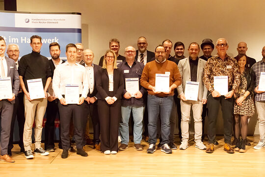 Gruppenfoto der Damen und Herren die ausgezeichnet wurden. Diese halten auch ihre Urkunde in die Kamera.