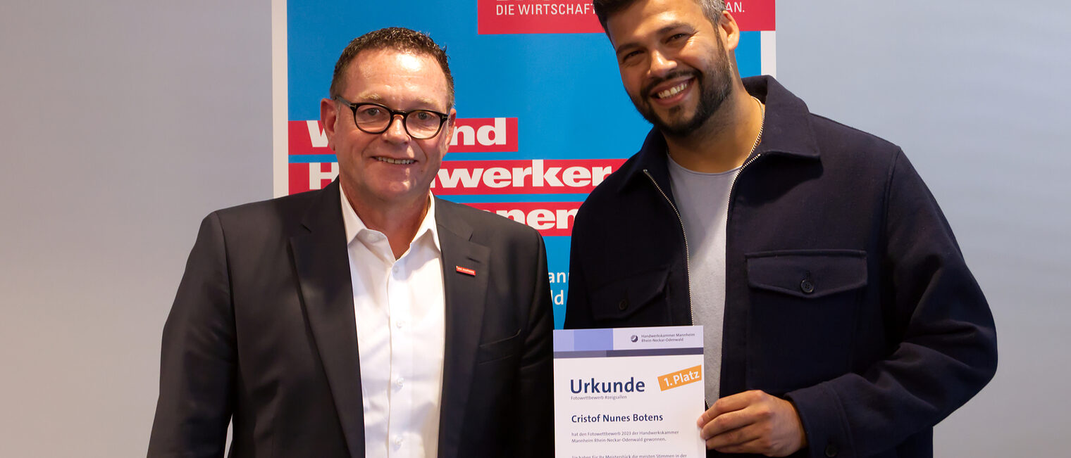 Der Gewinner des Fotowettbewerbs "#zeigsallen" 2023 bei den Meistern- Cristof Nunes Botens mit Handwerkskammerpräsident Klaus Hofmann