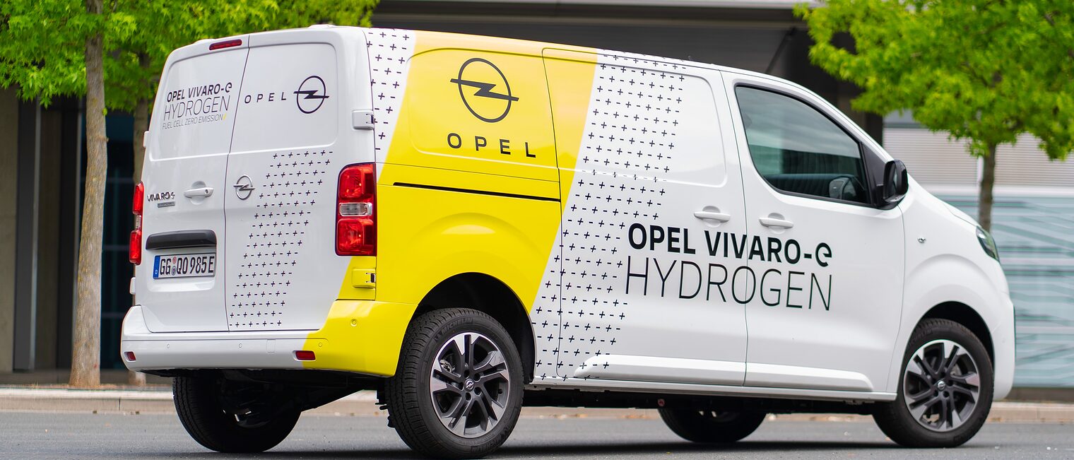 Weißer Transporter mit gelben Streifen und dem Opel Logo und der Aufschrift Opel - VIVARO - e HYDROGEN 