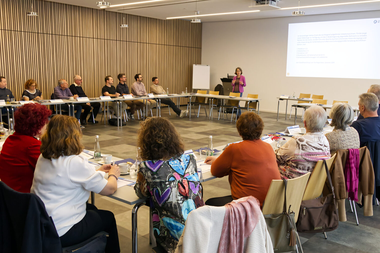 Prüfer in U-Form sitzend und die Referentin anschauend