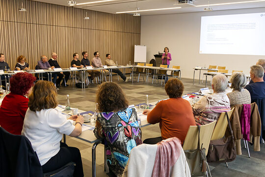 Prüfer in U-Form sitzend und die Referentin anschauend