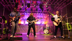 Vier Musiker auf der Bühne mit Bassgitarre, Gitarren und Schlagzeug