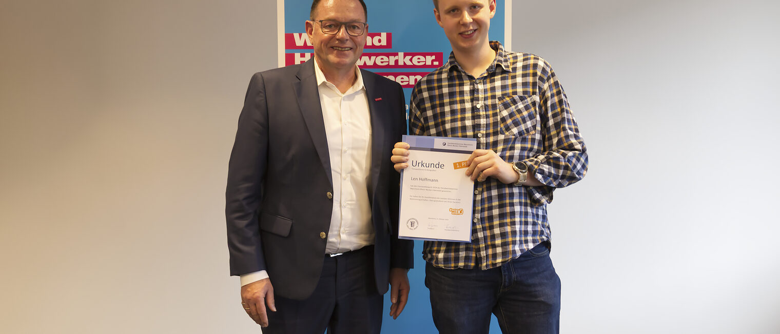 Der Gewinner des Fotowettbewerbs "#zeigsallen" 2024 bei den Gesellen - Len Hoffmann mit Handwerkskammerpräsident Klaus Hofmann
