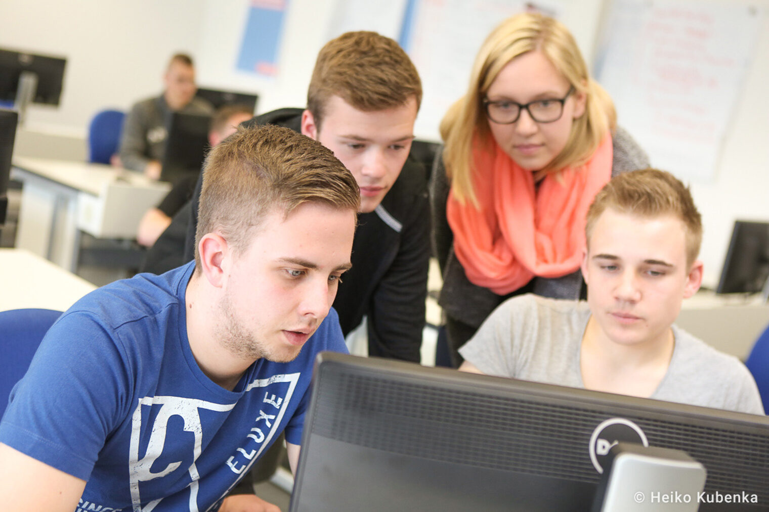 eine Gruppe junger Erwachsener sitz vor einem Computer Auszubildende sitzen in einer Arbeizsgruppe vor dem Computer