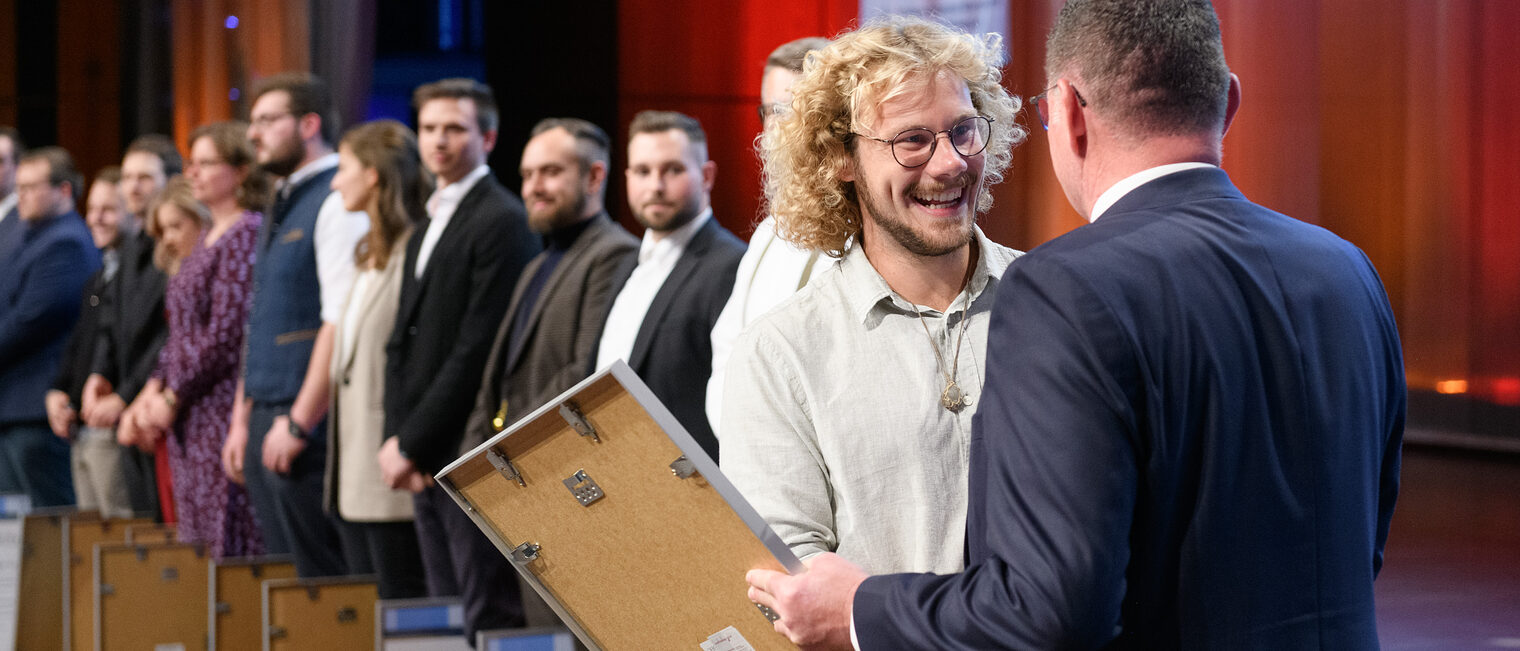 Handwerkskammerpräsident Klaus Hofmann gratuliert Schreiner/Tischlermeister Luca Distler