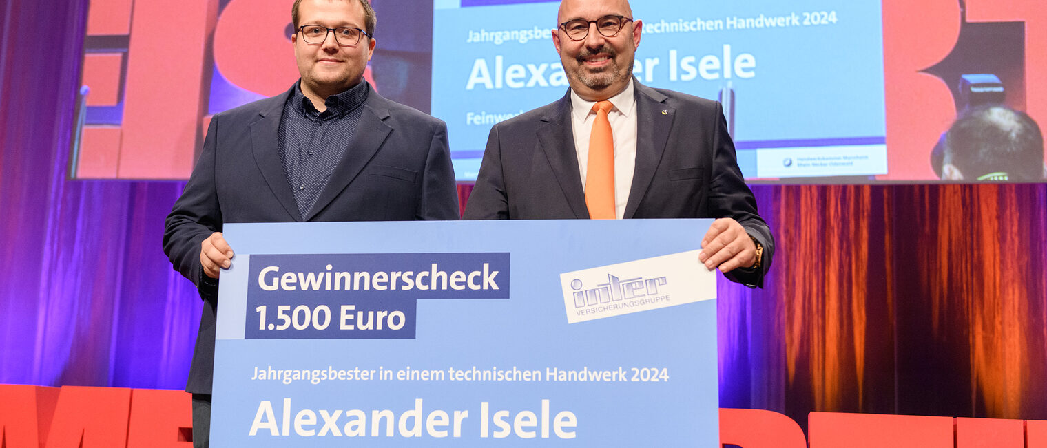 Michael Schillinger von INTER Versicherungsgruppe überreicht dem Preisträger Feinwerkmechanikermeister Alexander Isele einen Scheck