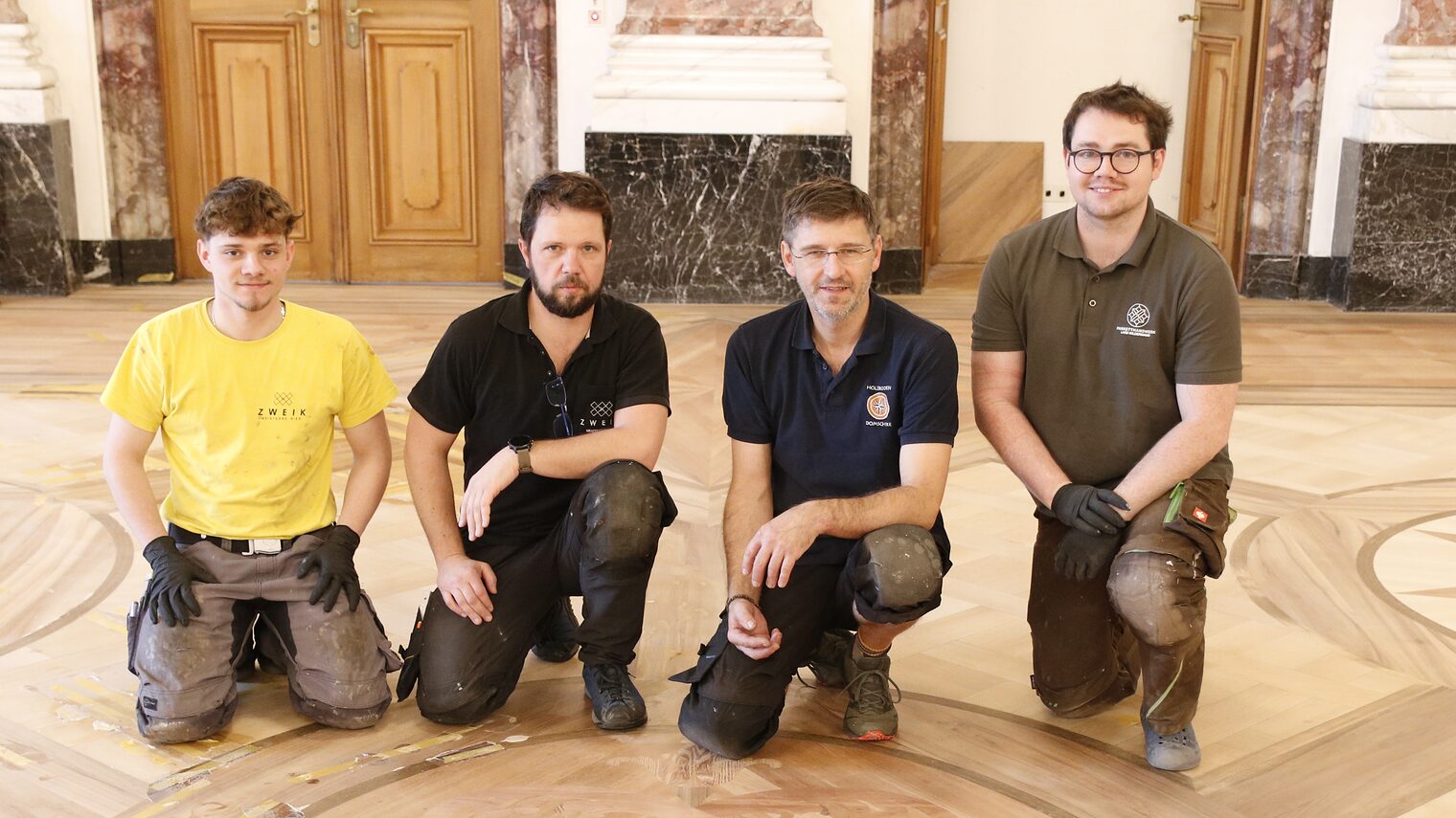 Azubi Joris Sturm und die Parkettrestauratoren Eddy Keilbach, Marko Domschke und Lars Wildermann (von links) vor einem der schönen Ornamente im Parkett des Rittersaals.