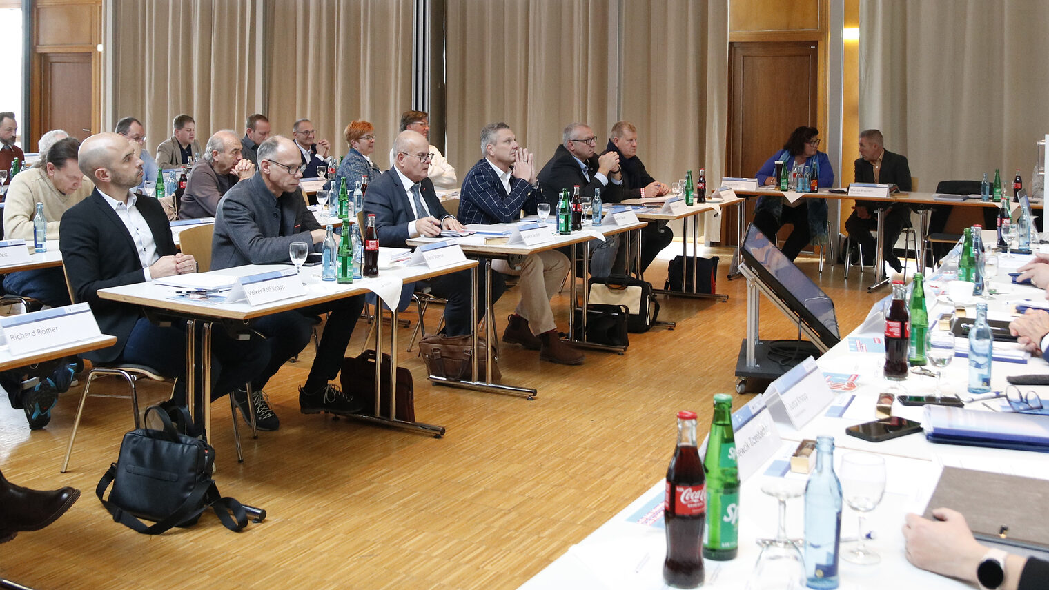 Die Mitglieder der Vollversammlung sitzen parlamentarisch angeordnet zur Führungsspitze. 