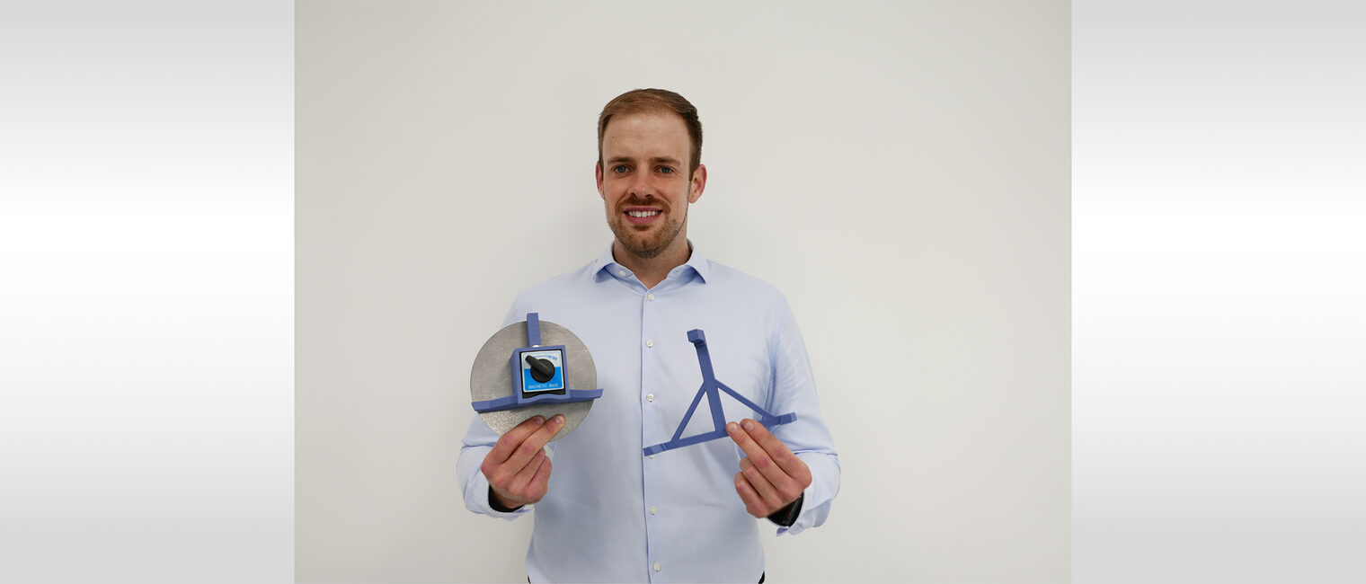 Sebastian Busch in blauen Hemd hält die Schablonen in die Kamera