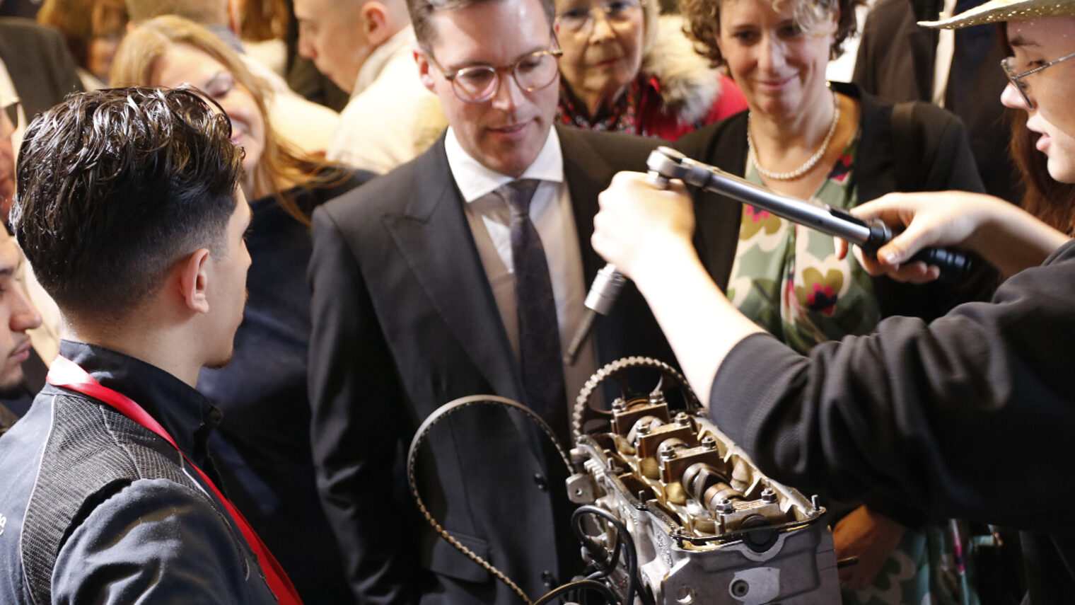 Menschen um einen Motor stehend