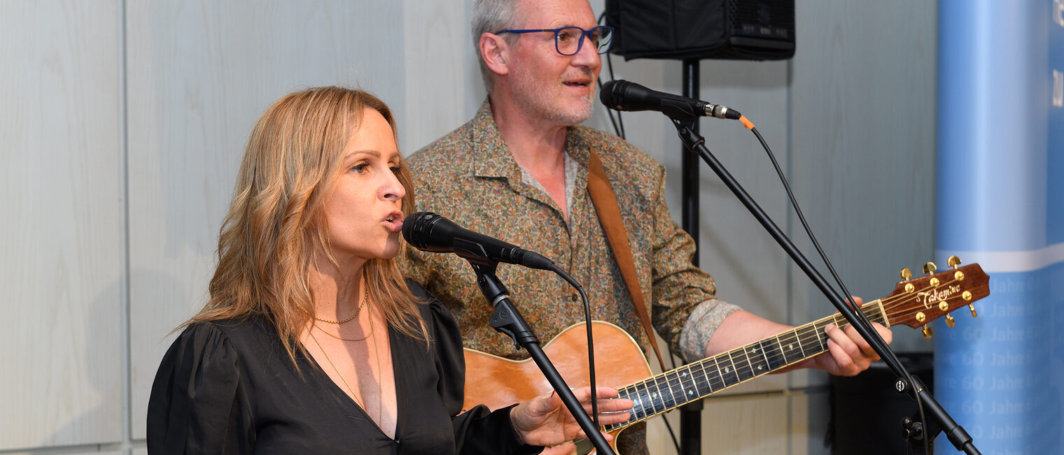 Die Band PureAcoustic besteht aus einer Frau, welche singt, und einem Mann welcher zusätzlich noch Gitarre spielt.