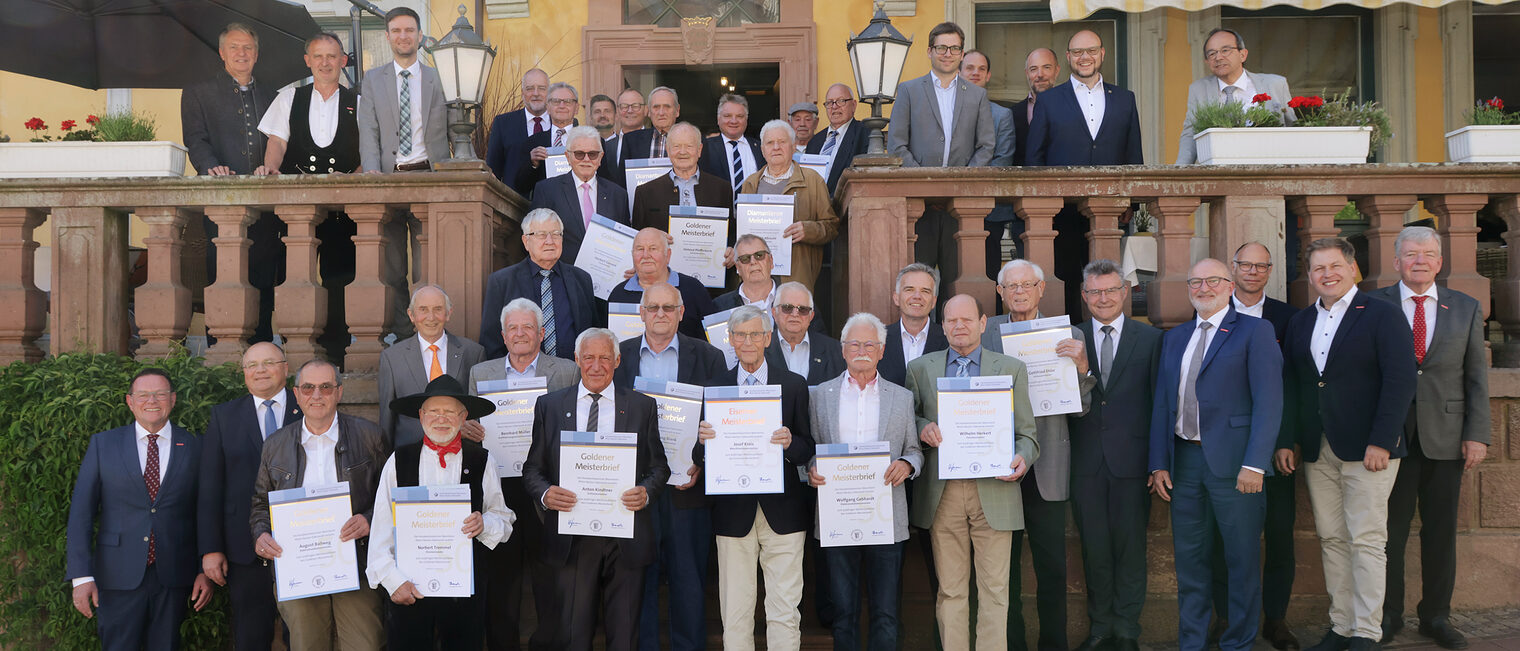 Handwerkskammer ehrte goldene, diamantene und eiserne Meister bei Veranstaltung Ein Gruppenfoto von mehreren Handwerksmeistern, die eine Urkunde von der Handwerkskammer erhalten.