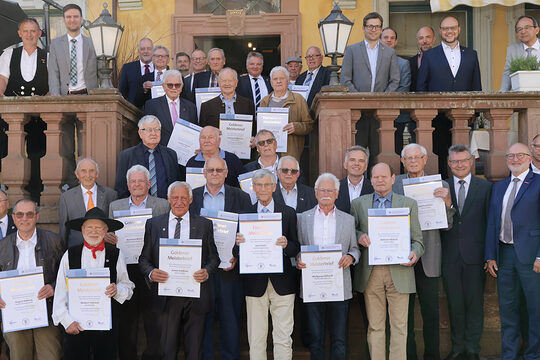 Ein Gruppenfoto von mehreren Handwerksmeistern, die eine Urkunde von der Handwerkskammer erhalten.