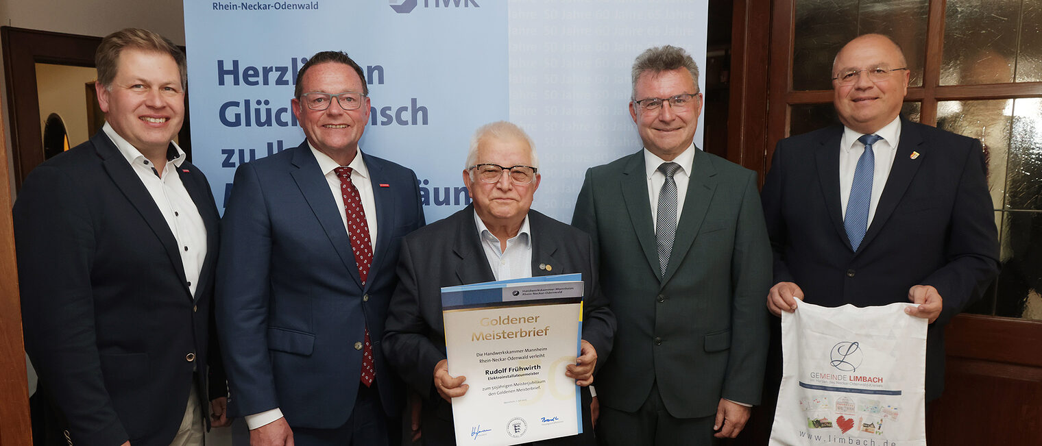 Überreichung der Urkunde zum Meisterjubiläum durch Herrn Klaus Hofmann, der Jubilar hält die Urkunde vor sich.