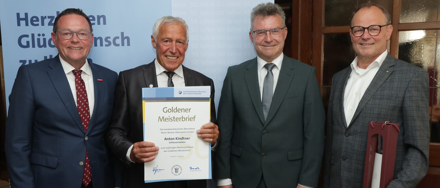 Überreichung der Urkunde zum Meisterjubiläum durch Herrn Klaus Hofmann, der Jubilar hält die Urkunde vor sich.