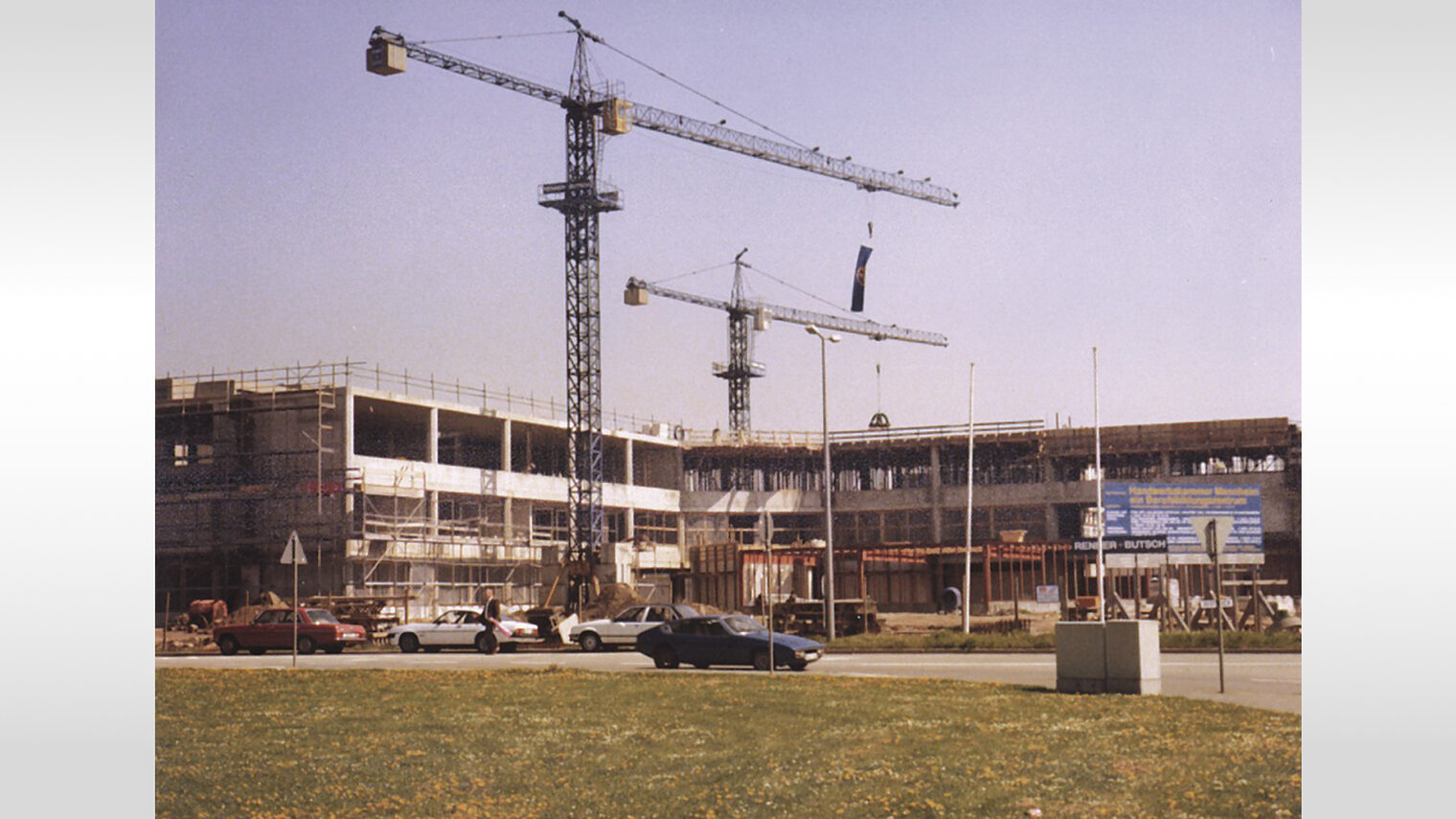 Die Fotografie zeigt den Rohbau der Bildungsakademie und zwei Kräne. 