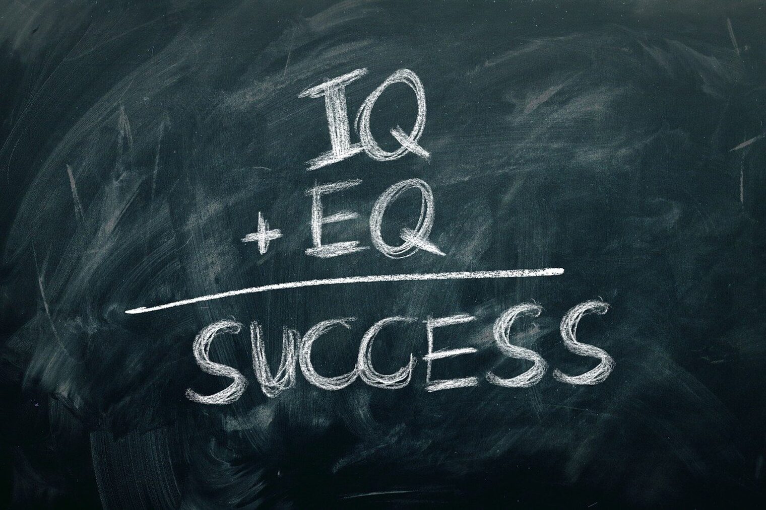 Emotionale Kompetenz Auf einer Tafel ist mit Kreide geschrieben: IQ+EQ= Success