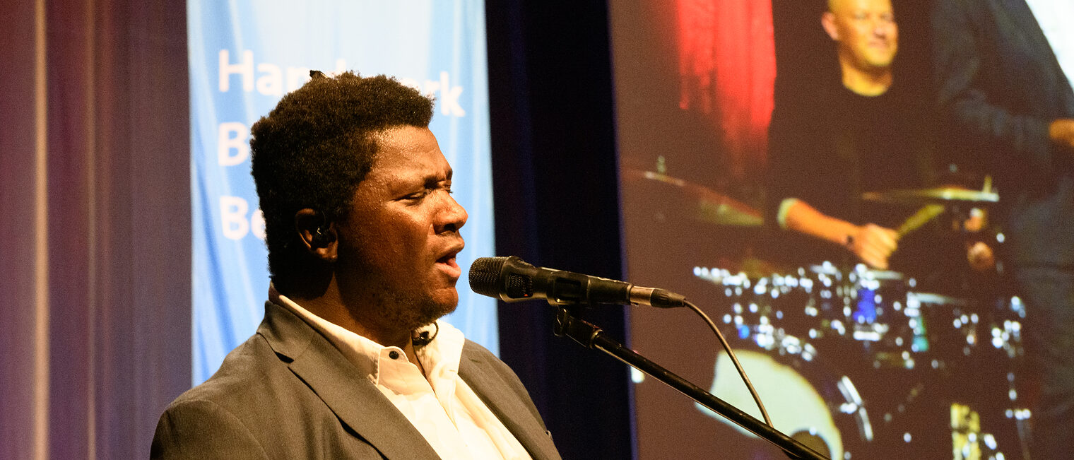 Ein Sänger einer Band singt in ein Mikrofon 