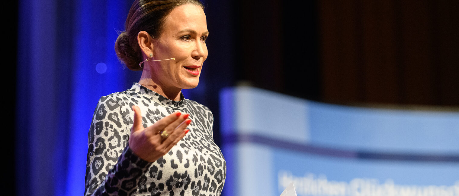 Eine Frau steht auf der Bühne und moderiert