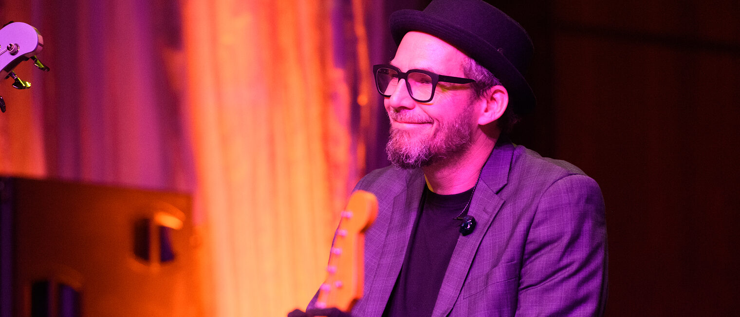 Musiker sitzt an seinem Klavier und lächelt