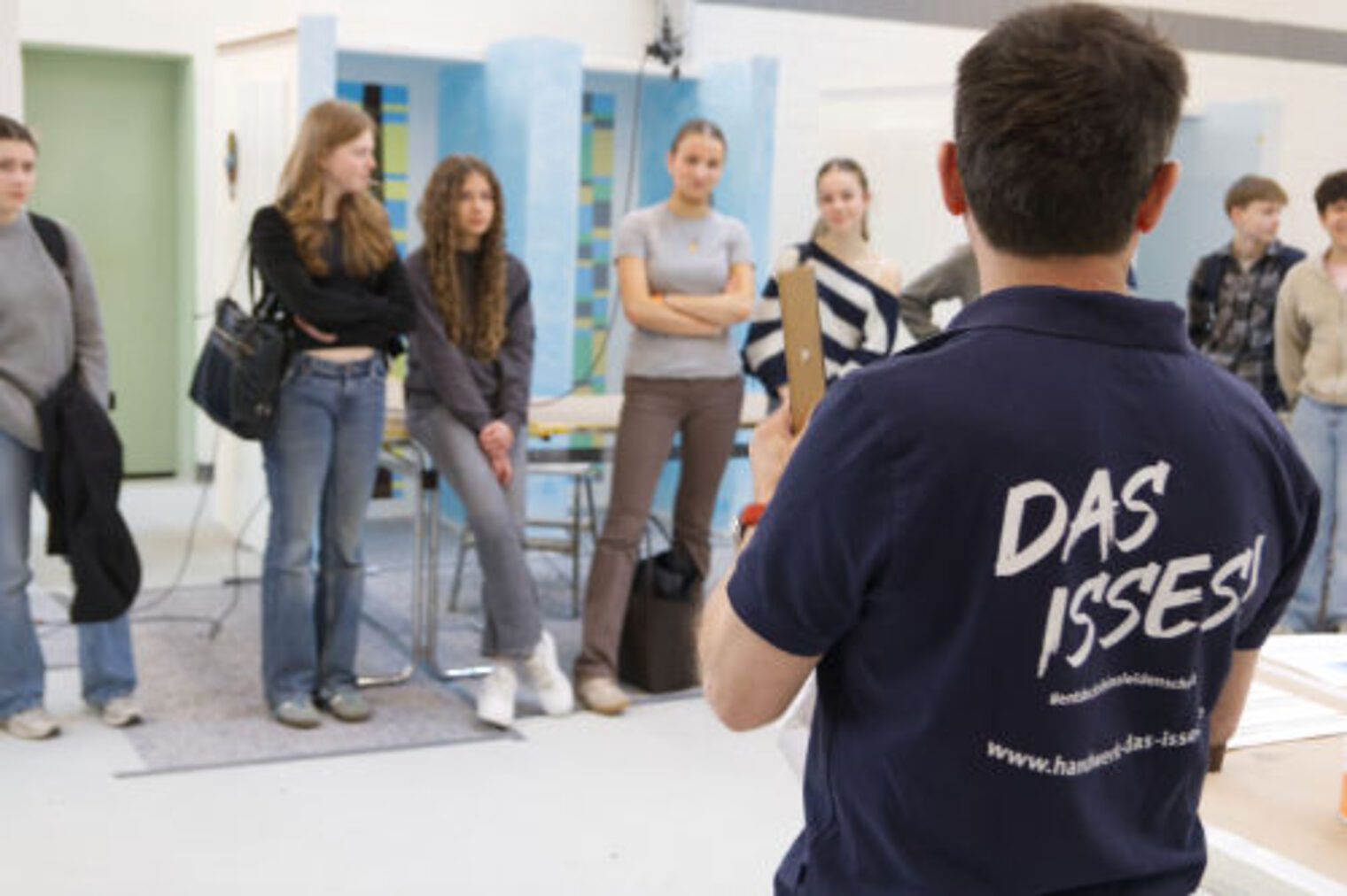 Ausbilder im "Das Isses" Shirt spricht vor einer Gruppe aufmerksamer Jugendlicher
