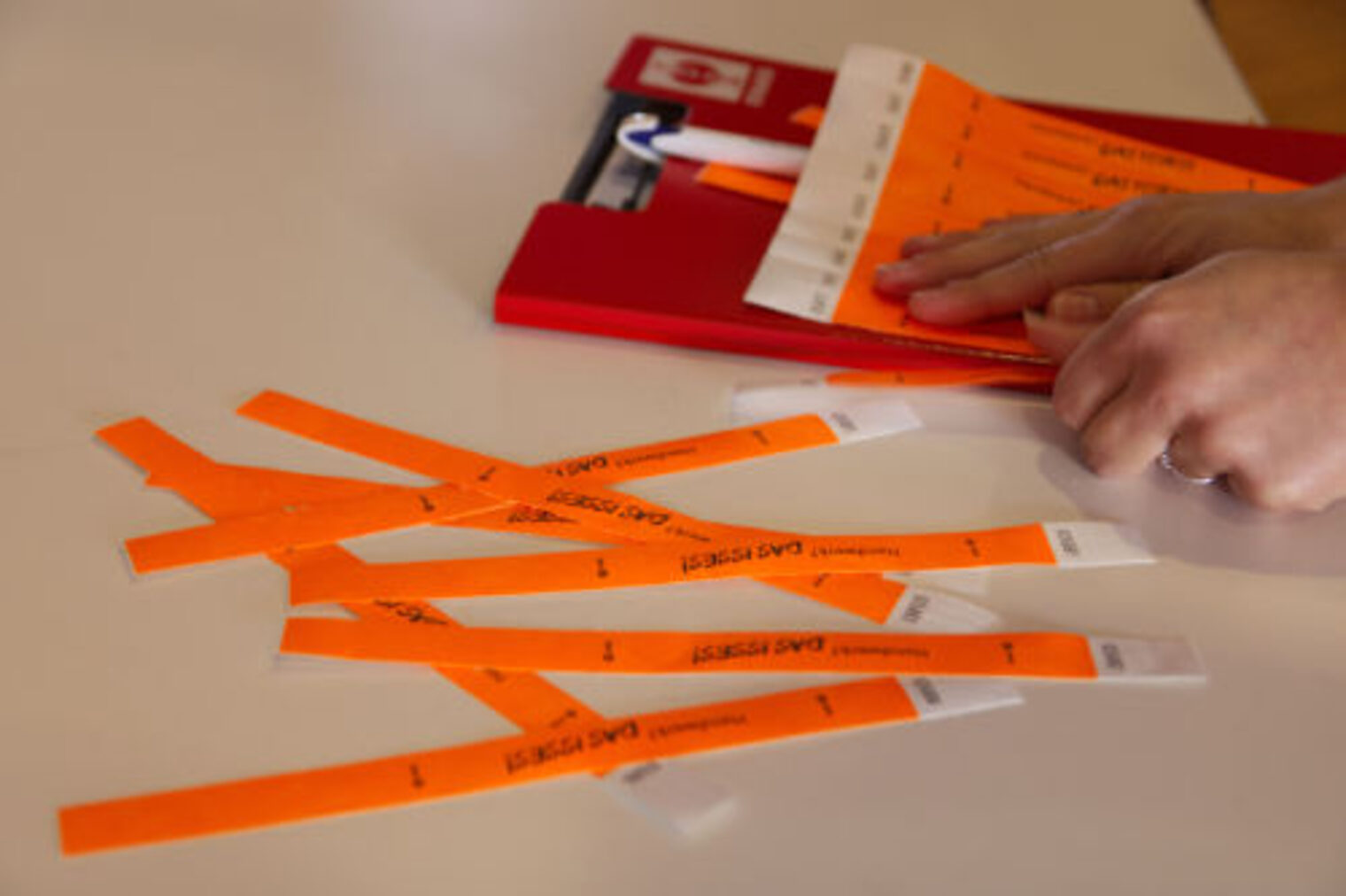 Orangefarbene Einlassbaender mit Aufschrift "Das isses" auf einem Tisch