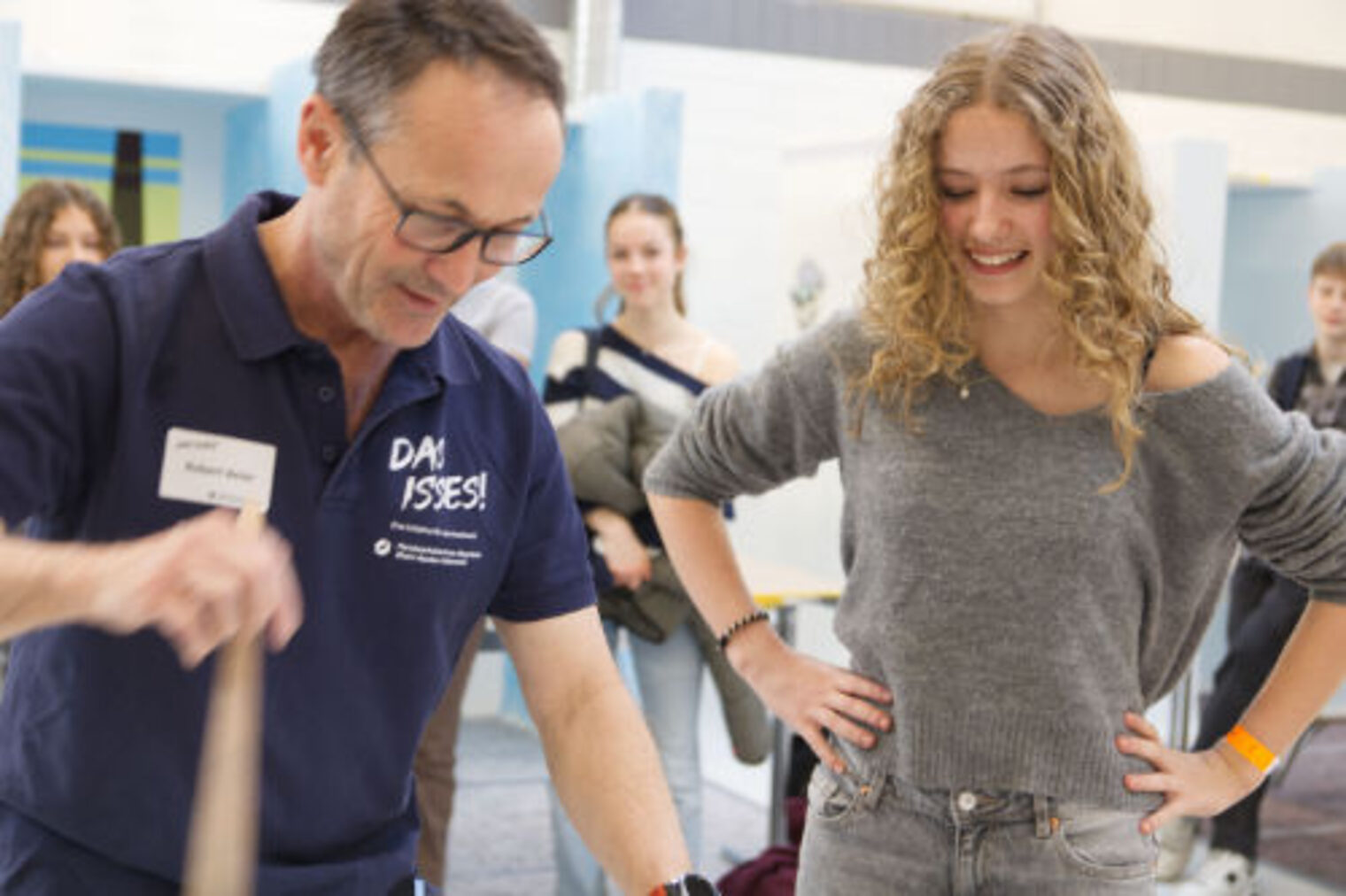 Ausbilder mit "Das Isses" Shirt zeigt lachender Jugendlicher Maltechnik mit einem Pinsel