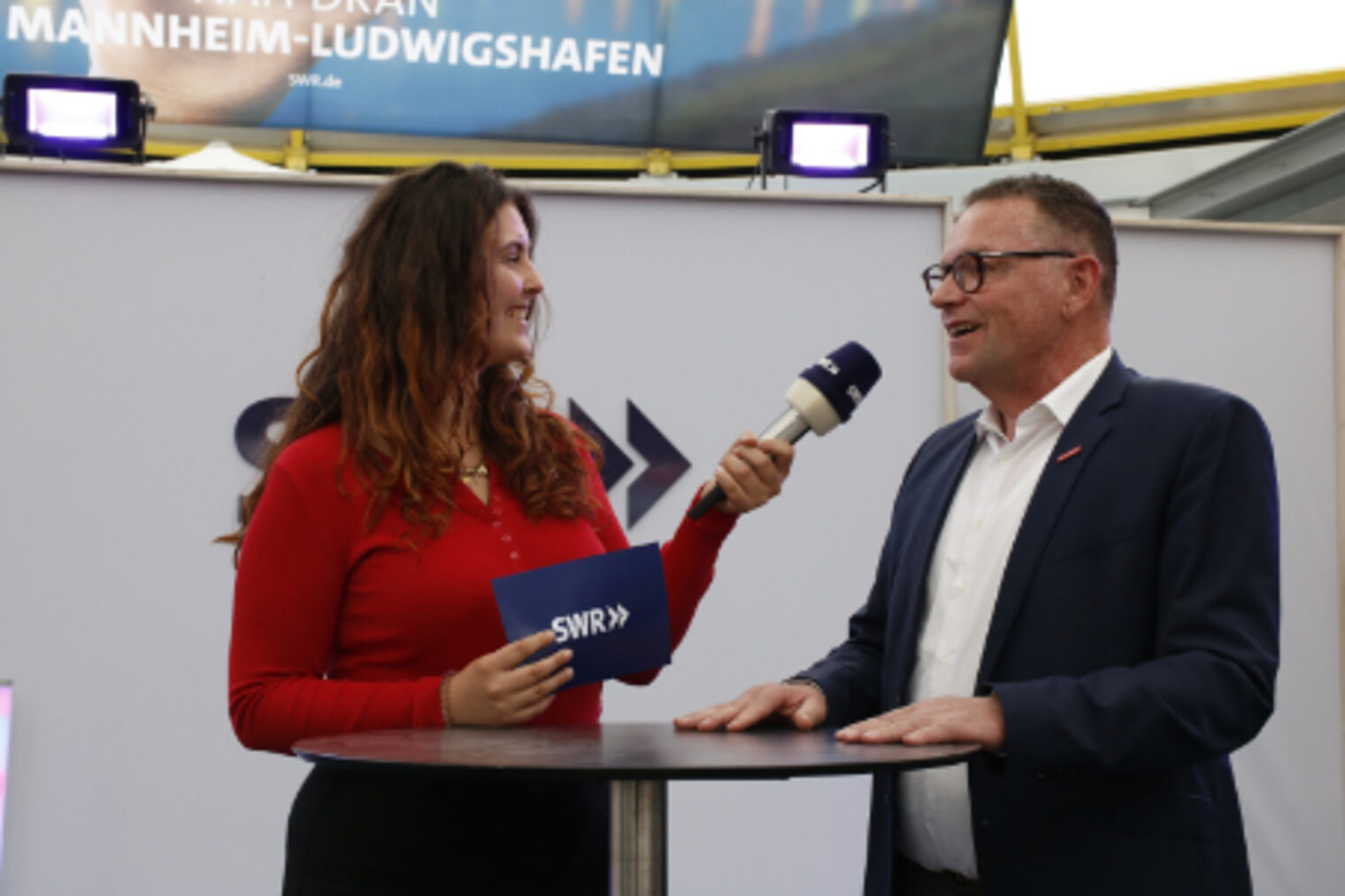 SWR-Moderatorin interviewt Präsident Klaus Hofmann im SWR-Gläsernen-Studio - Nah dran in Mannheim-Ludwigshafen auf dem Maimarkt Mannheim