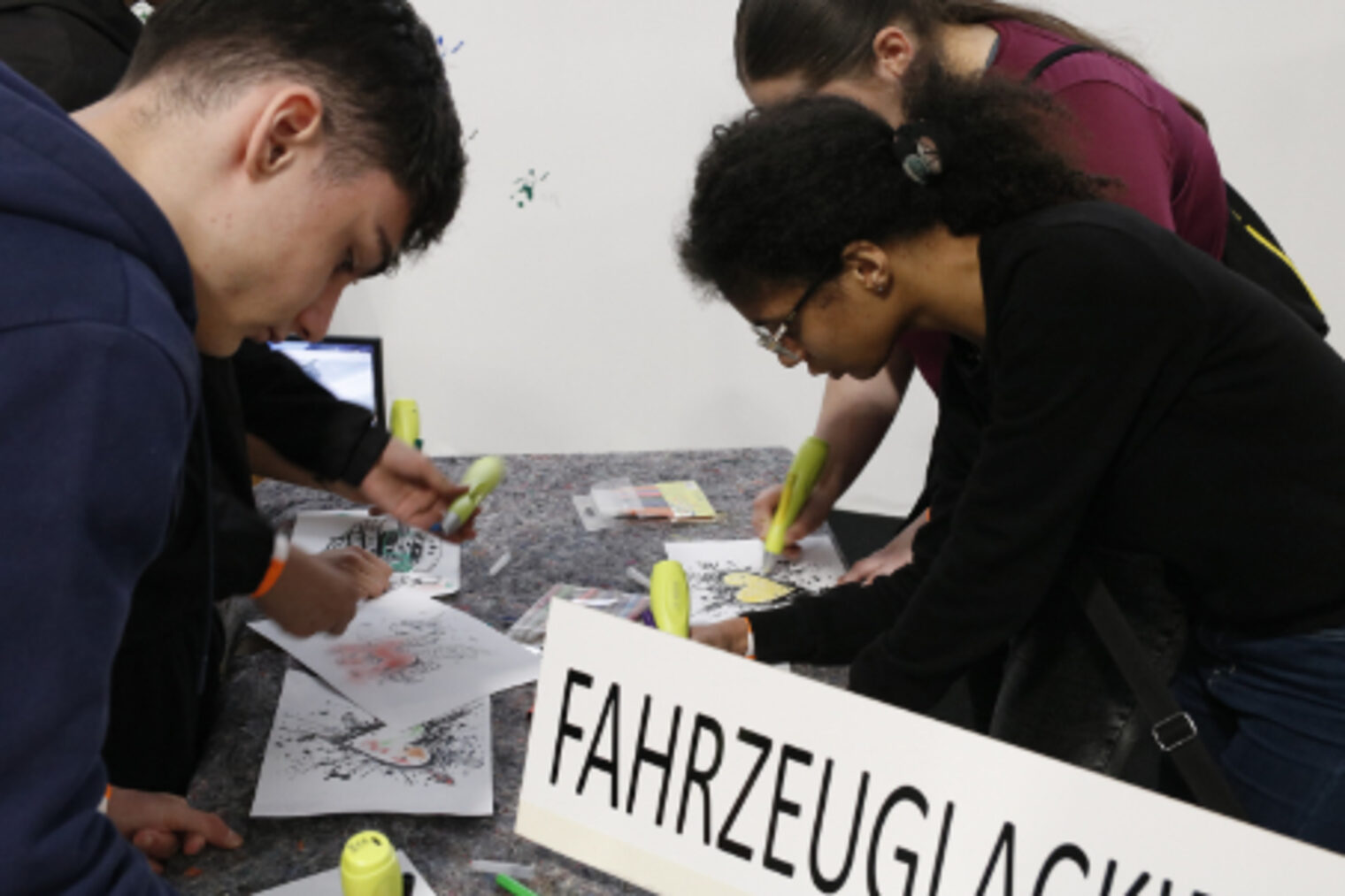 Jugendliche bemalen mit Stiften Vorlagen am Stand Fahrzeuglackierung auf dem Maimarkt Mannheim