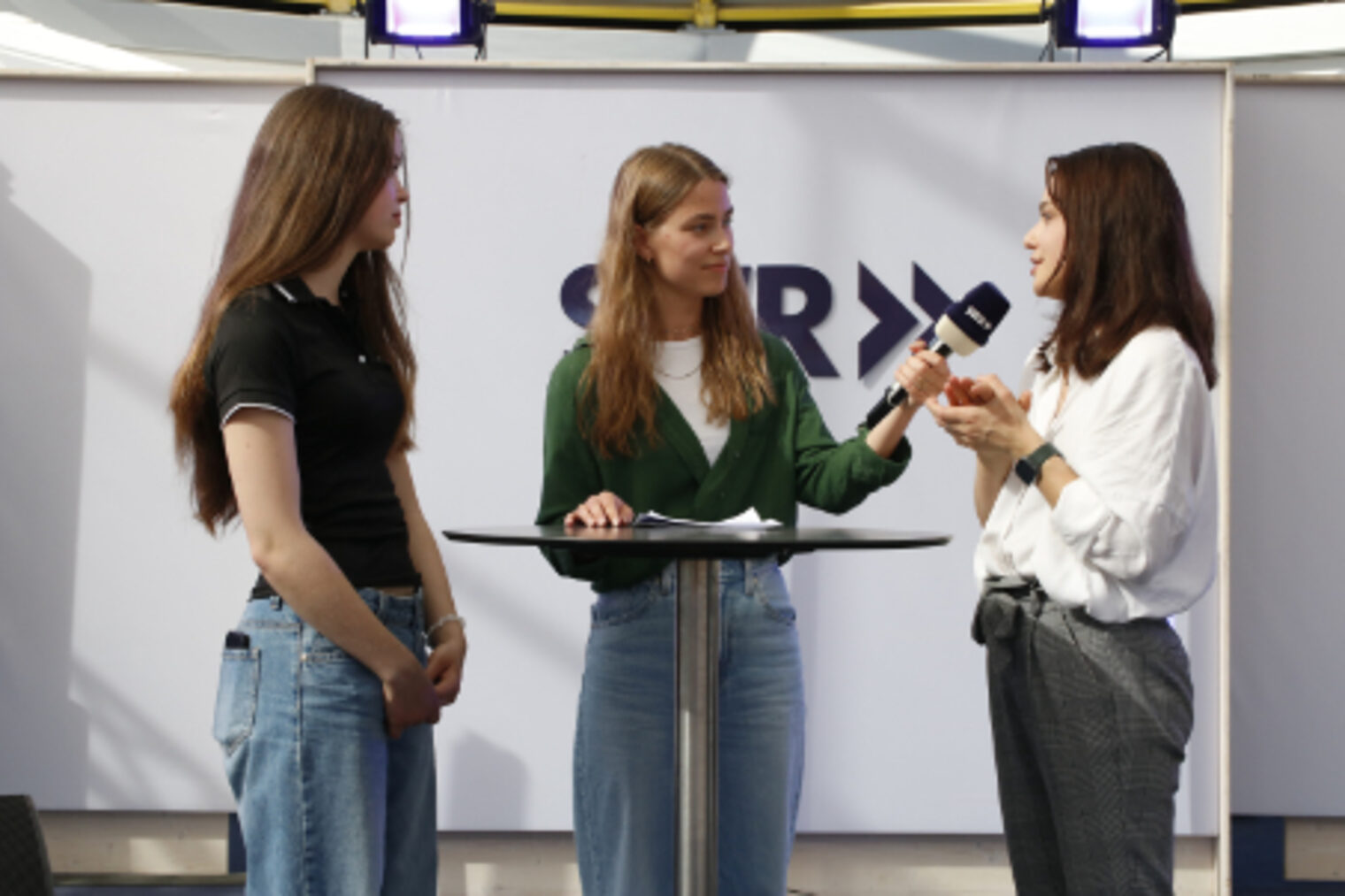 SWR-Moderatorin interviewt zwei junge Frauen am SWR-Messestand auf dem Maimarkt Mannheim