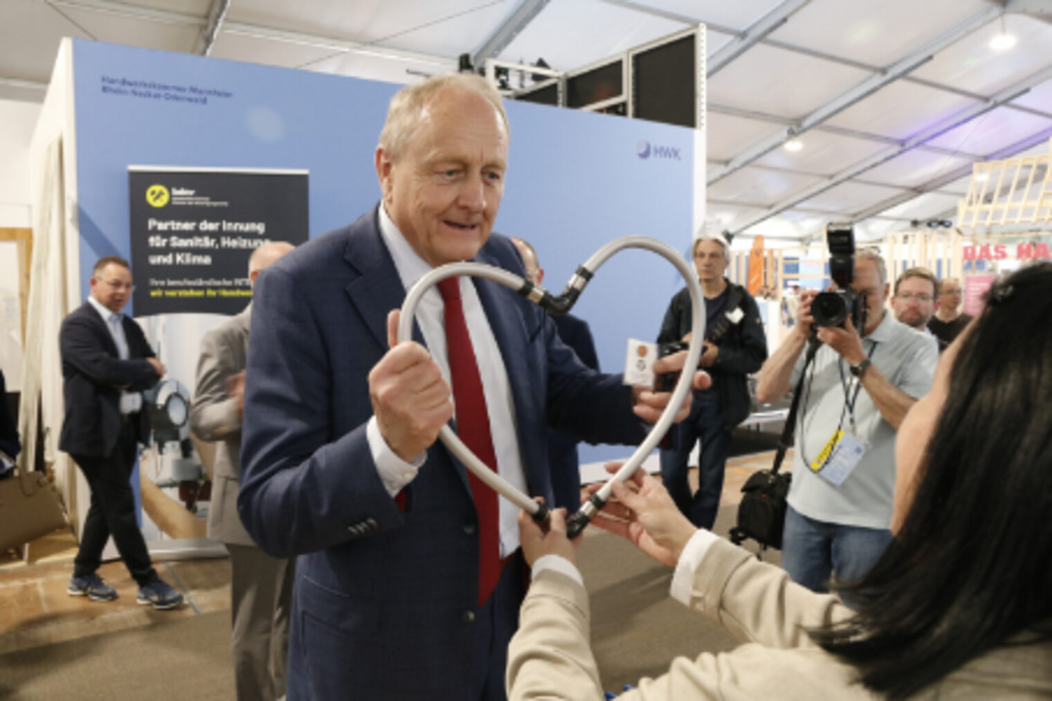 Präsident des Deutschen Bauernverbandes, Joachim Rukwied haelt beim Eroeffnungsrundgang Sanitaerschlauche in den Haenden am SHK-Stand auf dem Maimarkt Mannheim