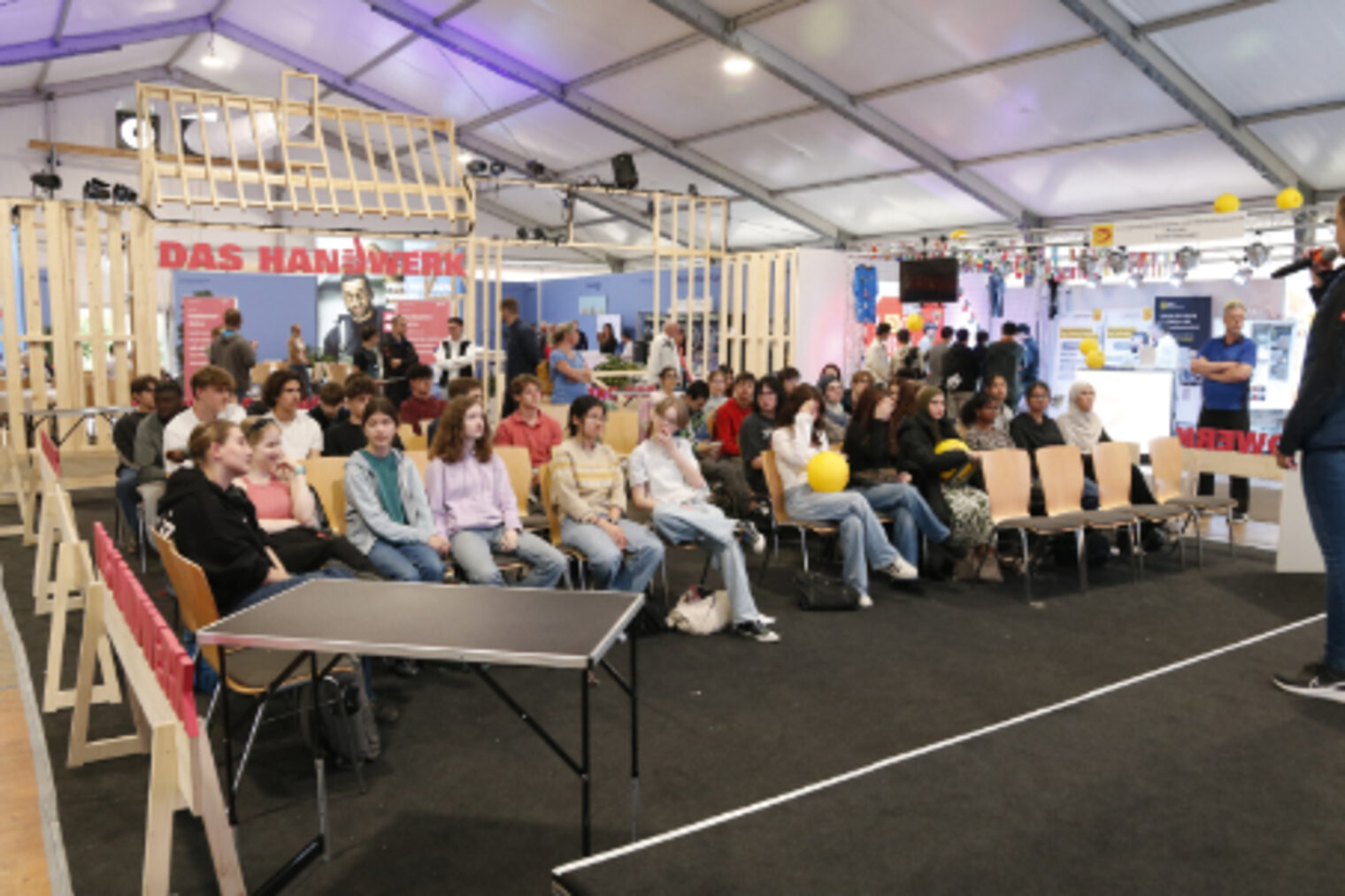 Schuelerinnen und Schueler sitzen im vollbesetzten Handwerker-Forum bei der Berufsorientierung auf dem Maimarkt Mannheim
