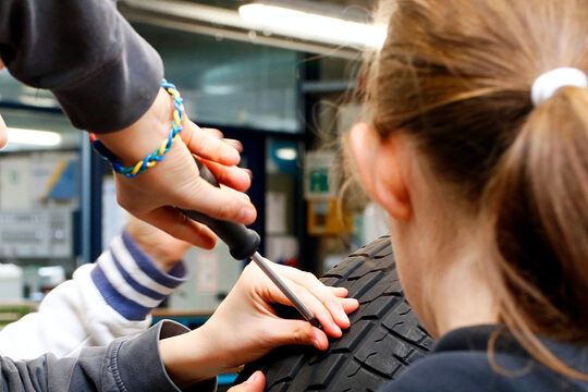 Zu sehen sind Mädchen beim Girls’Day in der Bildungsakademie der Handwerkskammer, an einem Reifen arbeiten.