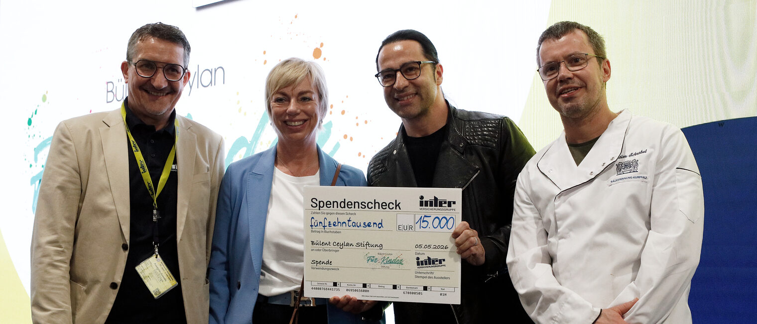 4 Personen bei der Überreichung eines Spendenschecks in Höhe von 15.000,- an die Bülent Ceylan für Kinder Stiftung