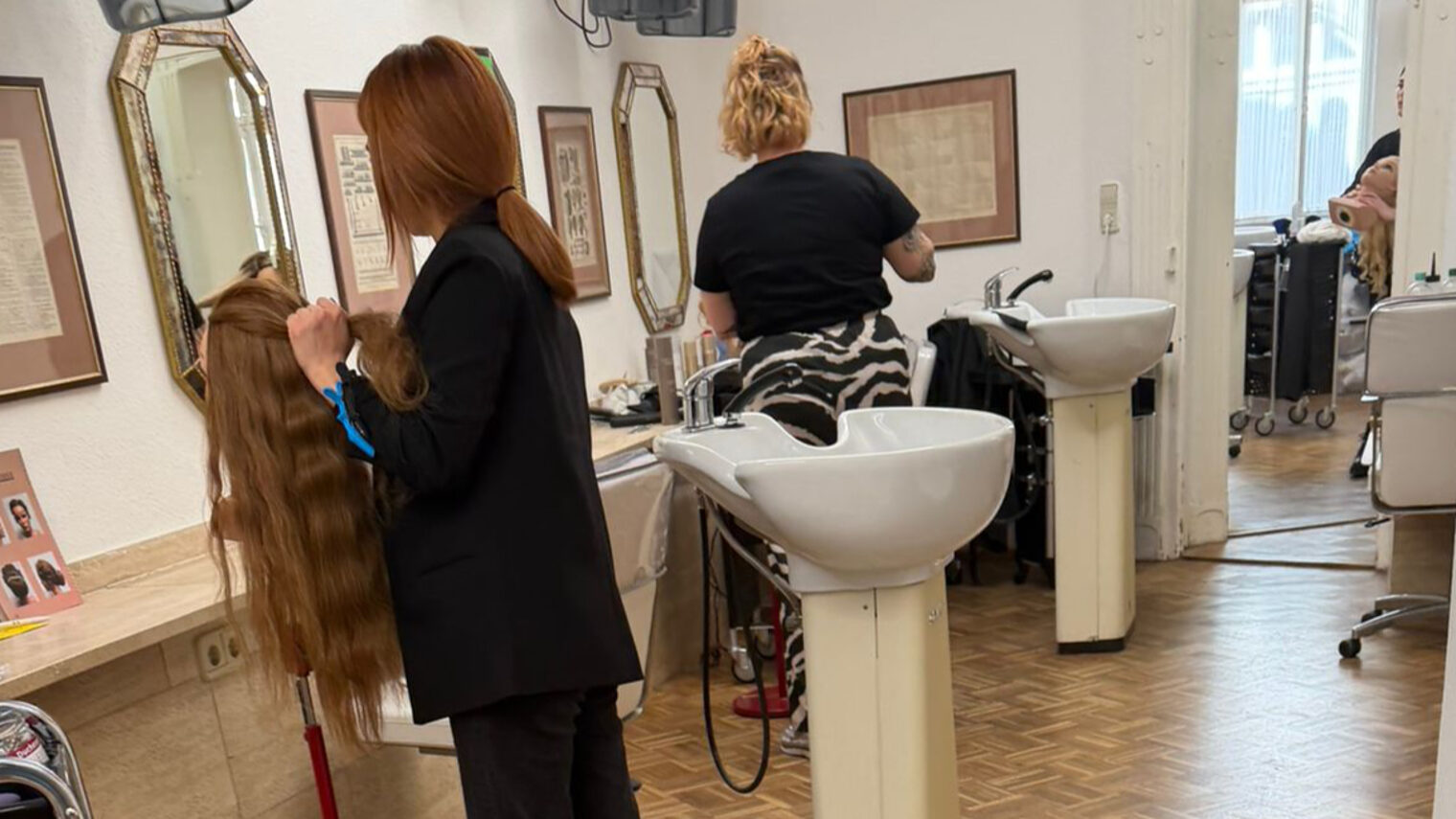 Zwei Friseurinnen beim Frisieren in einem Frisörsalon