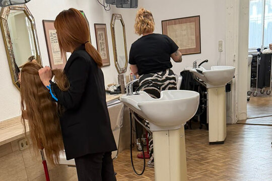 Zwei Friseurinnen beim Frisieren in einem Frisörsalon