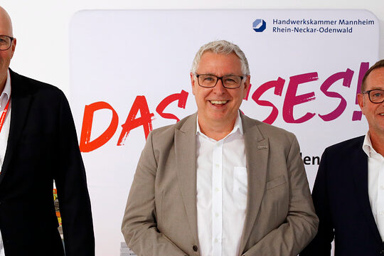 Drei Männer stehen lächelnd vor einem Banner der Handwerkskammer Mannheim Rhein-Neckar-Odenwald (v.l.): Norbert Hölscher (Bundesagentur für Arbeit), Thorsten Riehle (Wirtschaftsbürgermeister Mannheim), Klaus Hofmann (Kammerpräsident).